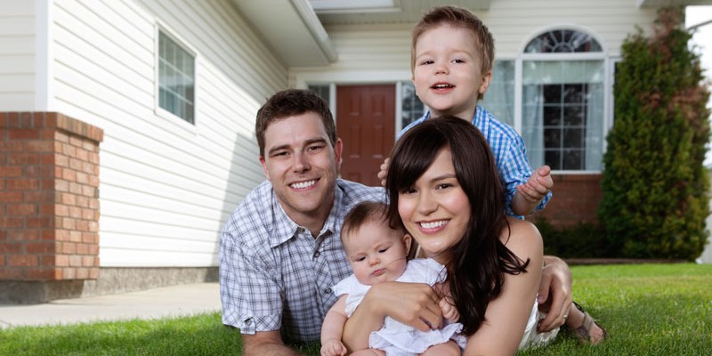 Happy Family of Four Lying Down on Grass